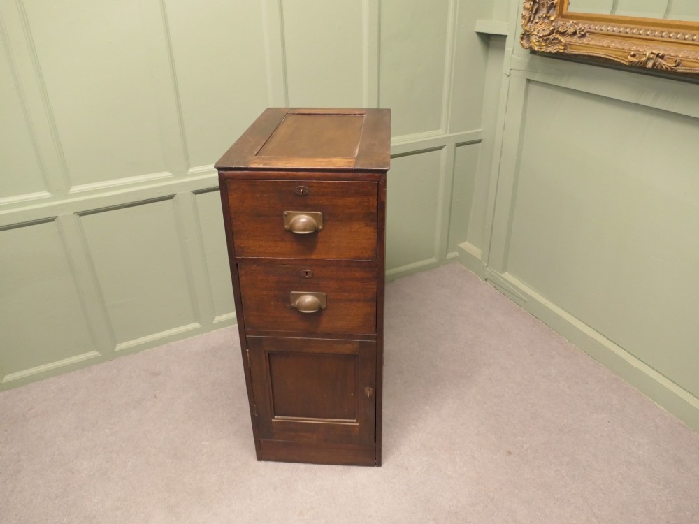 A narrow 19th-century mahogany bankers pedestal cabinet featuring two upper drawers with brass cup handles and a single panelled cupboard below. View II