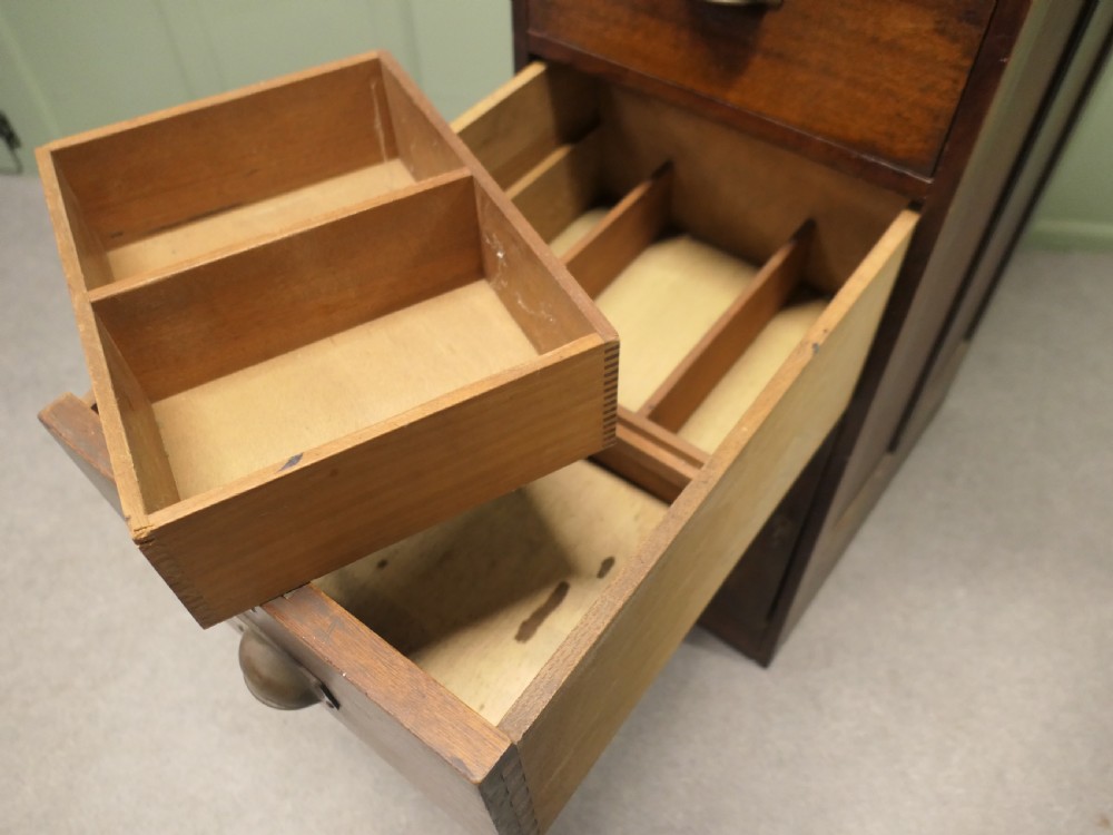 A narrow 19th-century mahogany bankers pedestal cabinet featuring two upper drawers with brass cup handles and a single panelled cupboard below. View VI