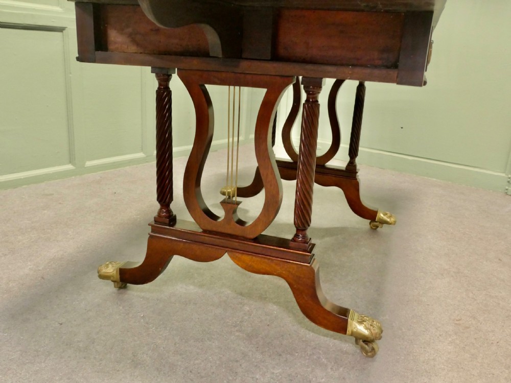 A Regency mahogany sofa table featuring two drop leaves, dual frieze drawers with brass handles, and lyre-shaped end supports terminating in brass lion paw castors. View VI