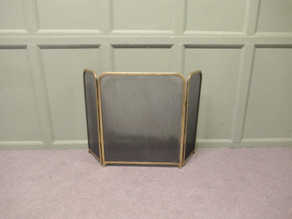 A three-panel folding fire guard featuring a tubular brass frame with black wire mesh screen inserts. View III