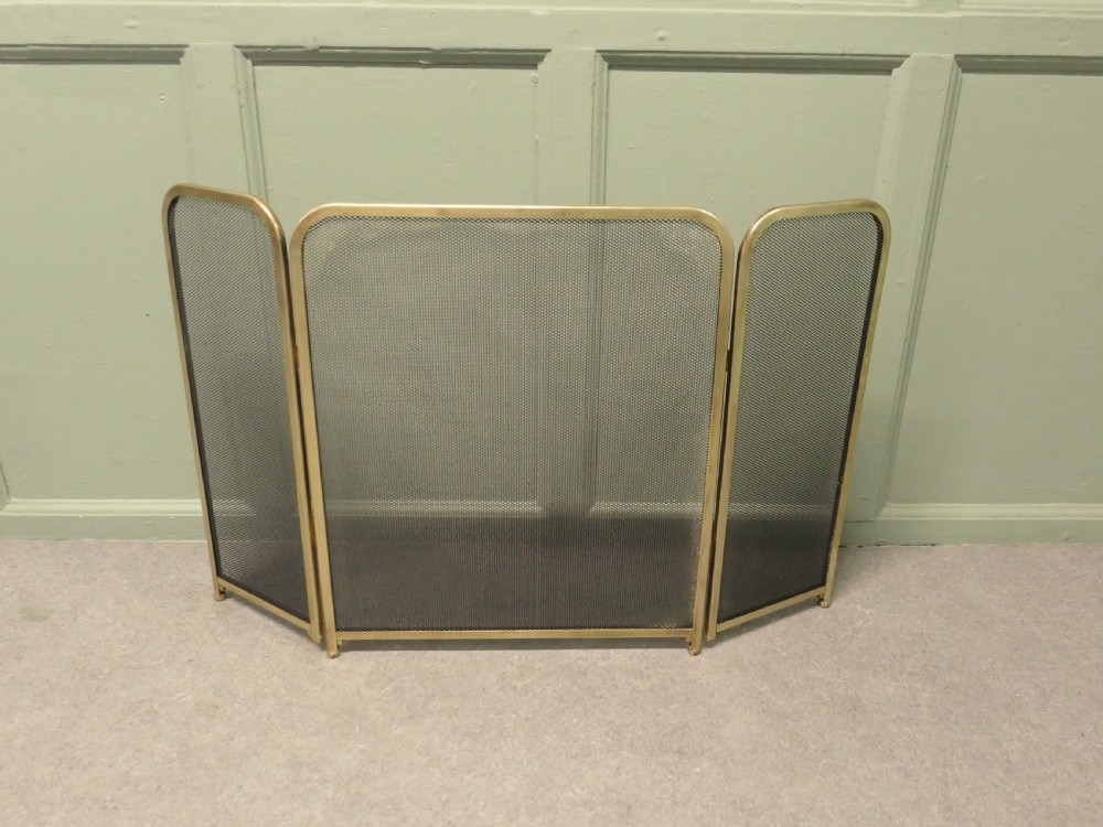 A three-panel folding fire guard featuring a tubular brass frame with black wire mesh screen inserts. View V