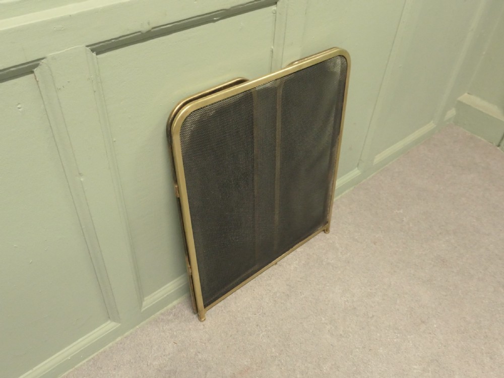 A three-panel folding fire guard featuring a tubular brass frame with black wire mesh screen inserts. View VII