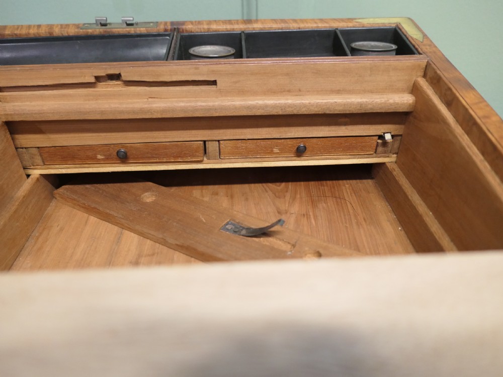 A rectangular 19th century pollard oak writing slope featuring brass corner mounts and a central brass keyhole. View II