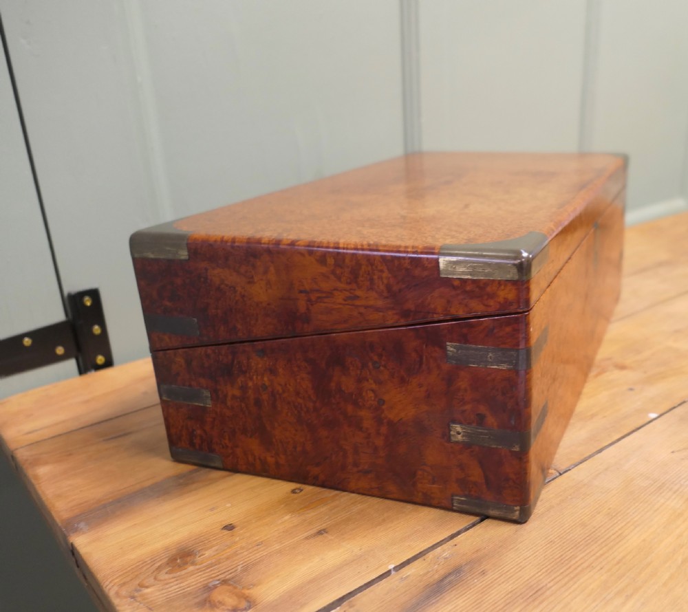 A rectangular 19th century pollard oak writing slope featuring brass corner mounts and a central brass keyhole. View VII