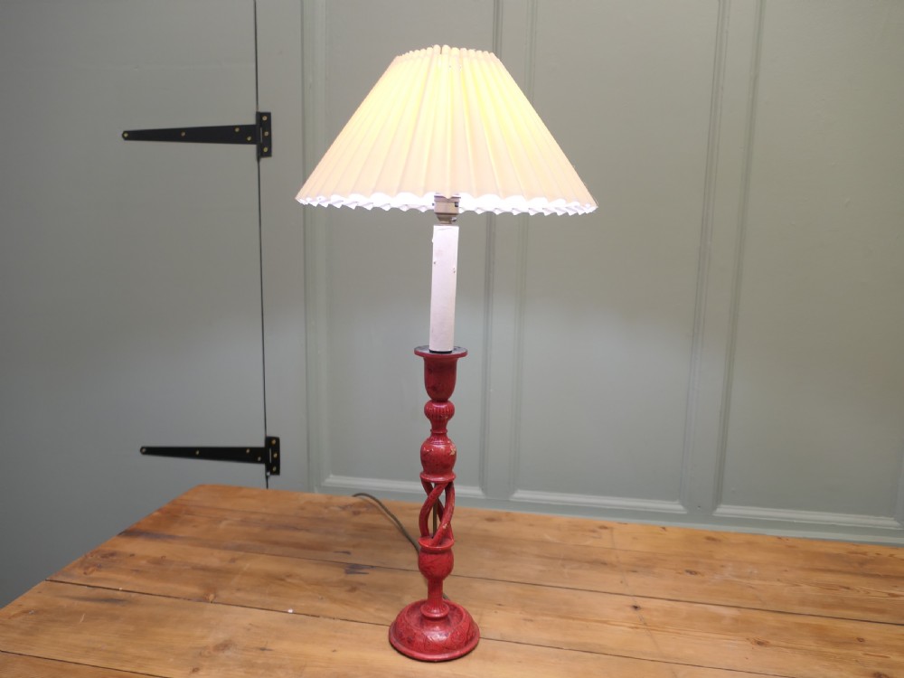 A red painted wooden table lamp featuring an open barley twist stem and a pleated cream lampshade. View V
