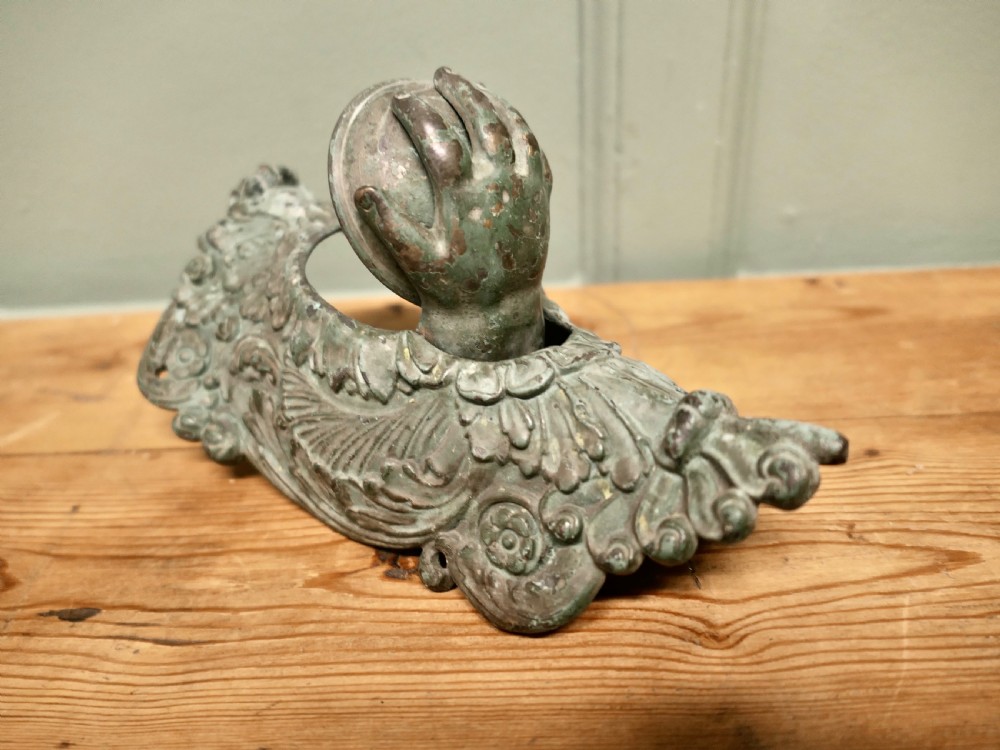 A cast bronze billiard corner pocket decorated with an acanthus leaf relief and a sculpted hand clasping a ball. View II