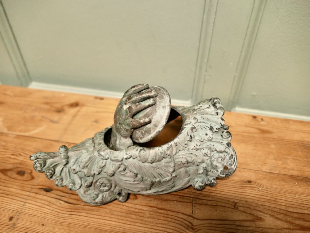 A cast bronze billiard corner pocket decorated with an acanthus leaf relief and a sculpted hand clasping a ball. View III