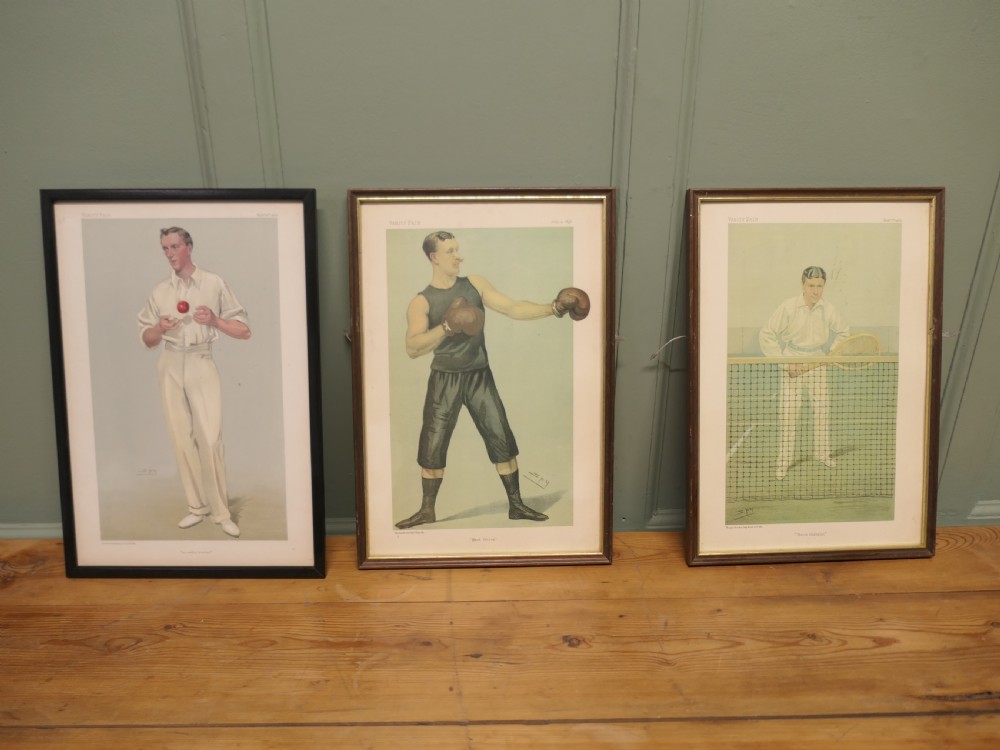 A collection of three framed antique Vanity Fair chromolithograph prints depicting a cricketer, a boxer, and a tennis player.