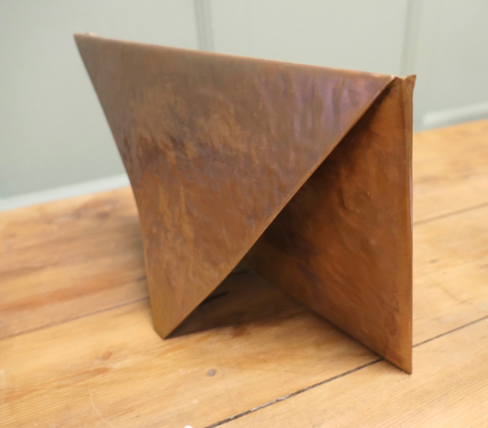 A beaten copper desk letter rack shaped like an envelope with a brass central stud detailing. View III