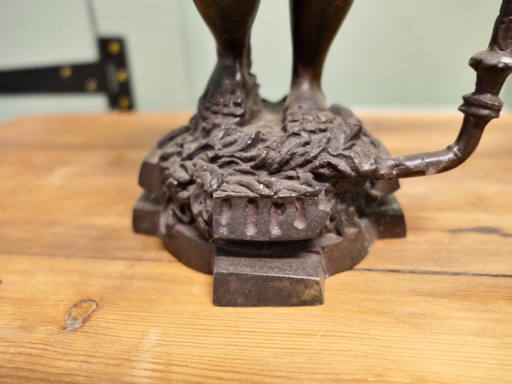 A pair of dark patinated cast brass figural candlesticks depicting standing figures in patterned tunics and turbans holding raised candle nozzles. View II