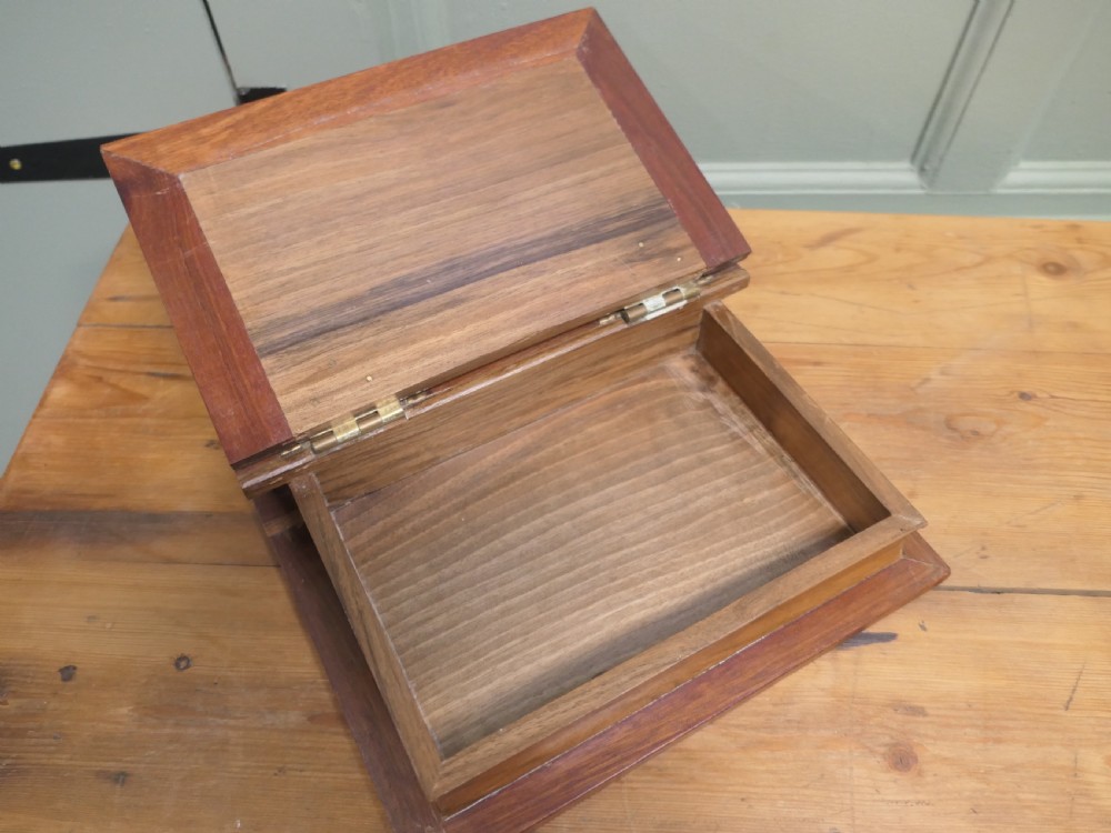 An Art Nouveau carved wooden book-shaped box with brass hinges featuring a relief carving of a seated figure surrounded by organic scrollwork. View II