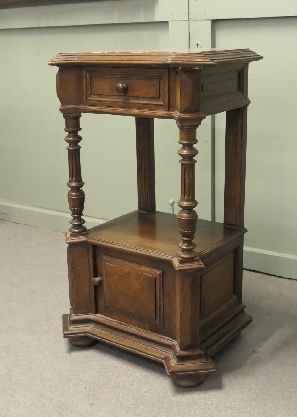 A 19th-century French walnut side cabinet with a pink marble inset top, a single upper drawer, turned columns, an open shelf, and a lower cupboard door. View V