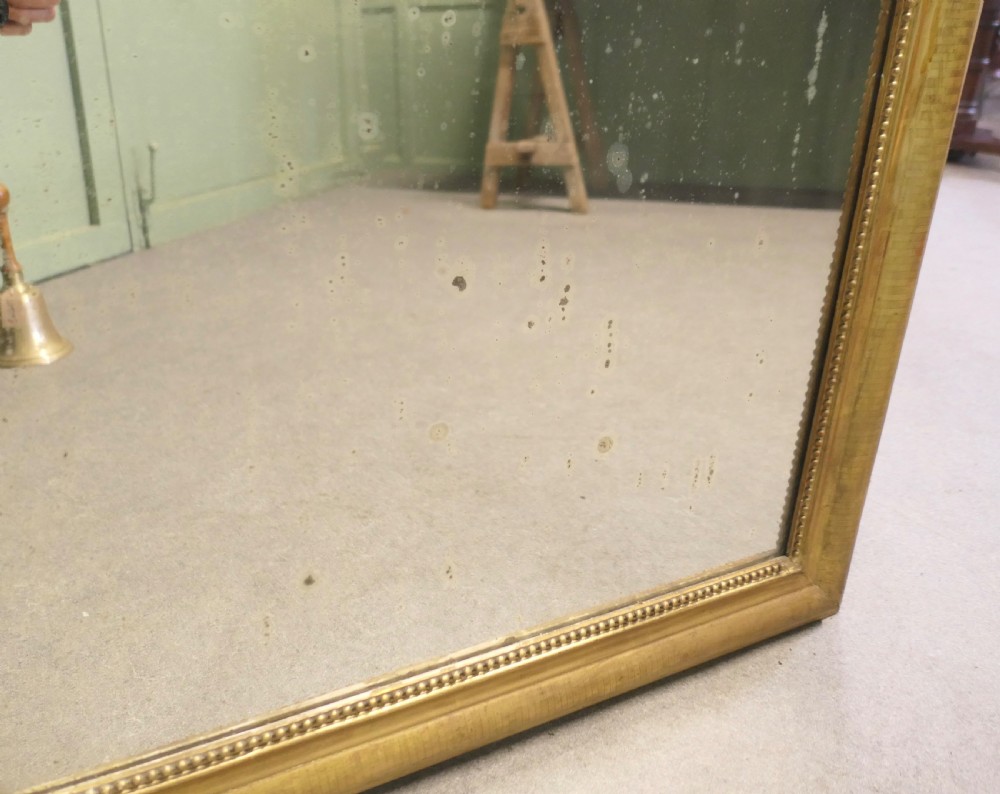 A 19th-century French Louis Philippe mirror featuring a gold gilded frame with rounded upper corners and beaded inner trim. View II