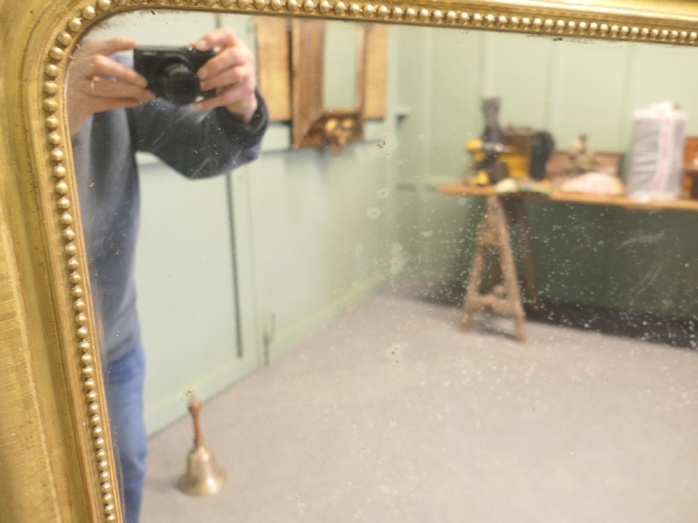 A 19th-century French Louis Philippe mirror featuring a gold gilded frame with rounded upper corners and beaded inner trim. View V