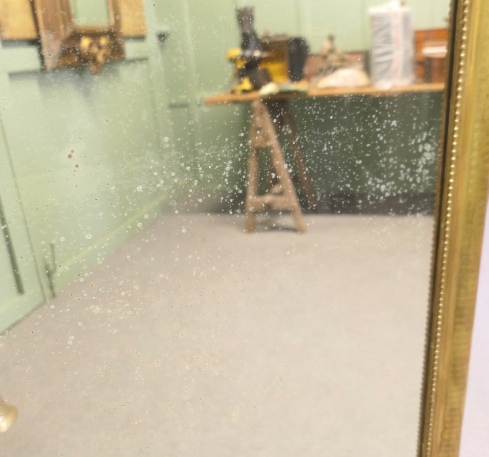 A 19th-century French Louis Philippe mirror featuring a gold gilded frame with rounded upper corners and beaded inner trim. View VI