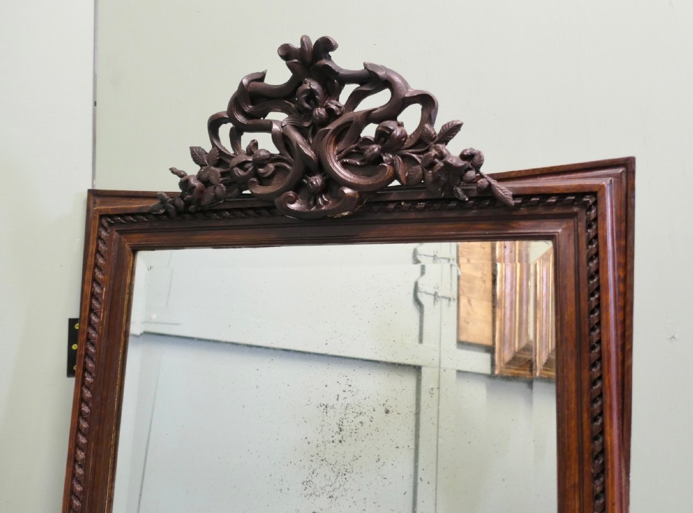 A rectangular dark oak wall mirror featuring a carved twist border and an ornate openwork carved scroll crest at the top. View III
