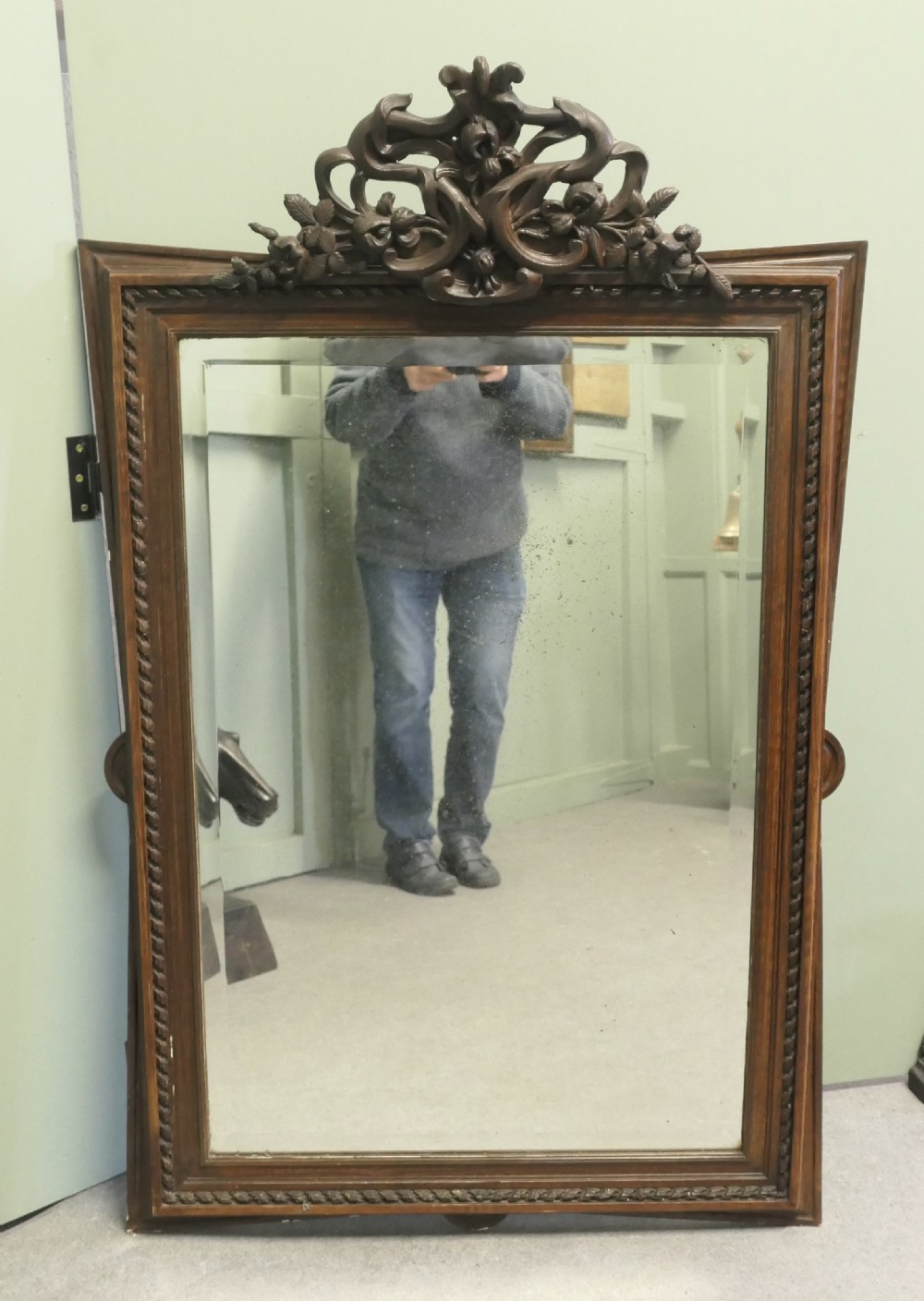 A rectangular dark oak wall mirror featuring a carved twist border and an ornate openwork carved scroll crest at the top. View VII