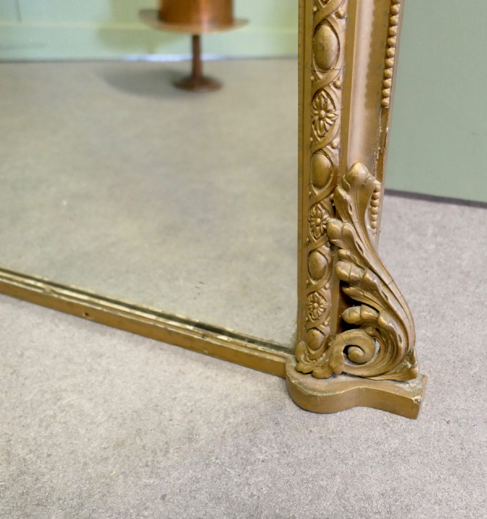 A tall 19th-century French Louis Philippe full-length mirror featuring a gold gilded frame with rounded top corners, floral moulding, and acanthus leaf corner details. View VI