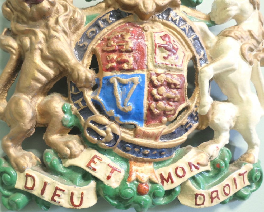 A painted cast iron wall plaque featuring the British Royal Coat of Arms with a gold lion and white unicorn supporting a quartered shield. View III