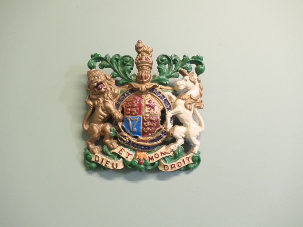A painted cast iron wall plaque featuring the British Royal Coat of Arms with a gold lion and white unicorn supporting a quartered shield. View VII