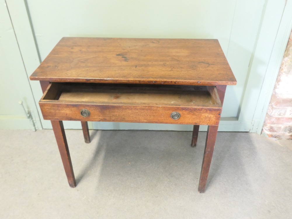 An early nineteenth-century warm brown oak writing table featuring a single frieze drawer with brass ring handles and four square tapered legs. View II