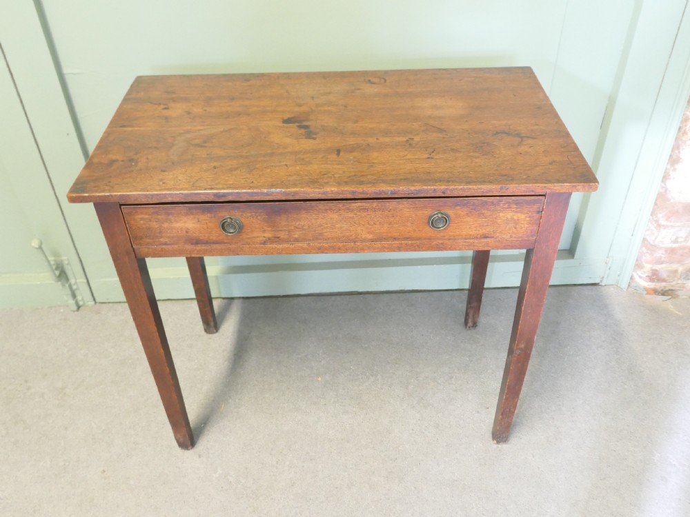 An early nineteenth-century warm brown oak writing table featuring a single frieze drawer with brass ring handles and four square tapered legs. View V