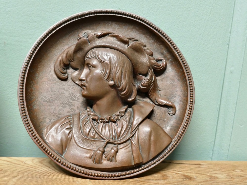 A pair of circular 19th-century copper wall plaques featuring raised relief portraits of a man and a woman in Renaissance attire within beaded borders. View III