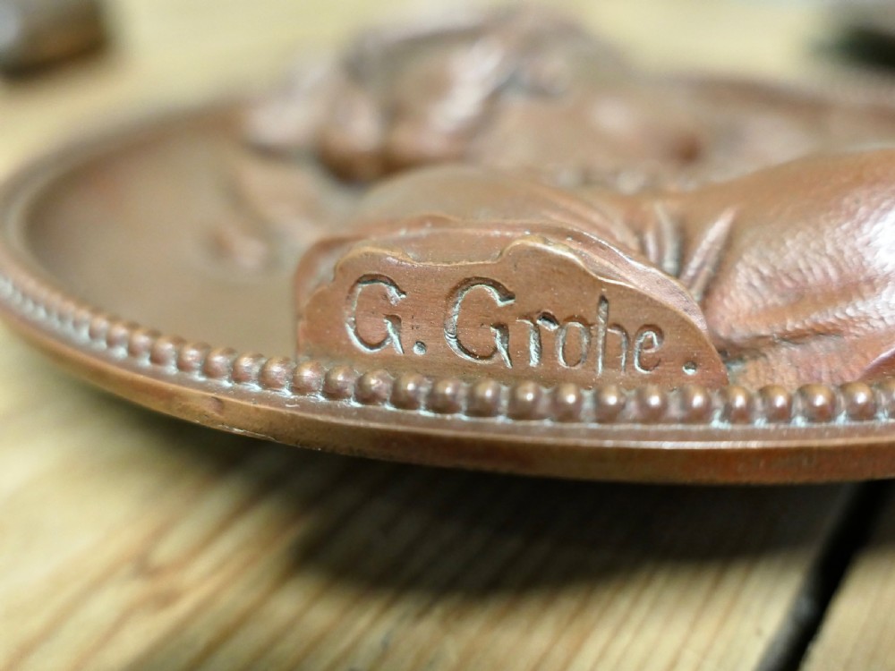 A pair of circular 19th-century copper wall plaques featuring raised relief portraits of a man and a woman in Renaissance attire within beaded borders. View V