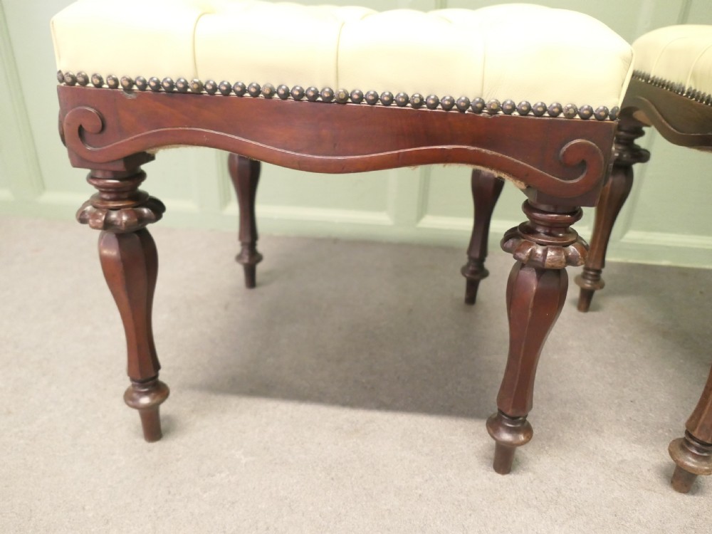 A pair of square deep-buttoned cream leather stools set on carved turned walnut legs with brass studding along the frames. View III