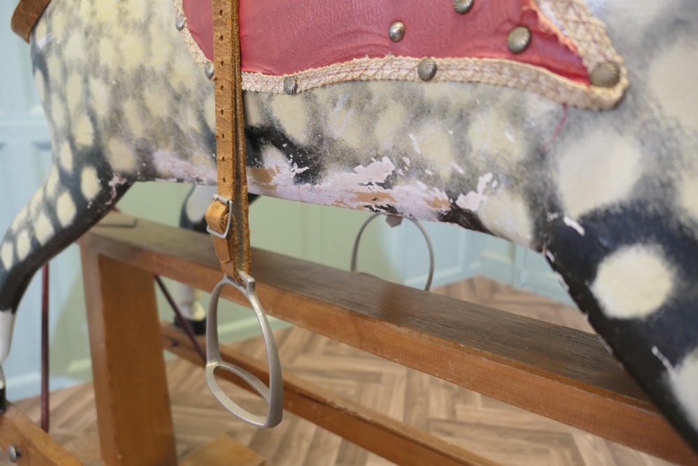 A large vintage dappled grey carved wooden rocking horse with blonde horsehair mane mounted on a pine safety stand. View VI