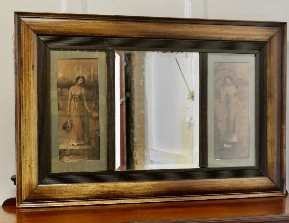 An Edwardian rectangular wooden wall mirror featuring a central mirror plate flanked by two framed vertical prints of women.