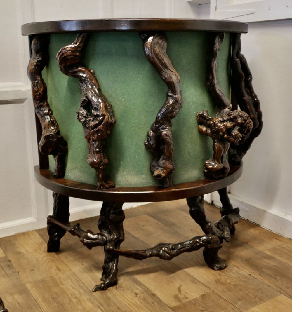 A curved home bar constructed from gnarled grapevine roots with a green padded front, accompanied by two matching round-topped bar stools. View II
