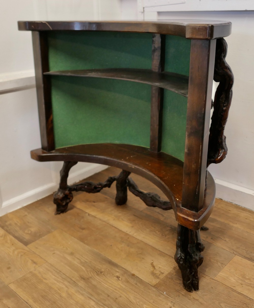 A curved home bar constructed from gnarled grapevine roots with a green padded front, accompanied by two matching round-topped bar stools. View V