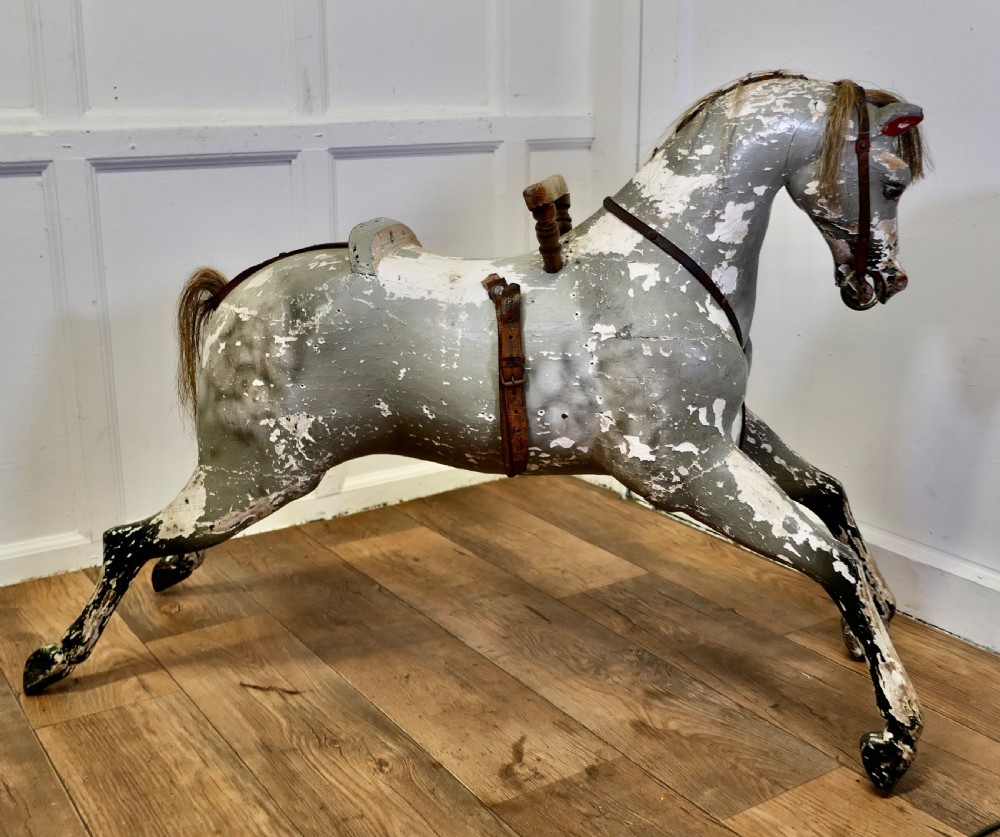 An early 19th-century hand-carved wooden horse featuring a distressed grey and white painted finish with leather harness and horsehair detail. View III