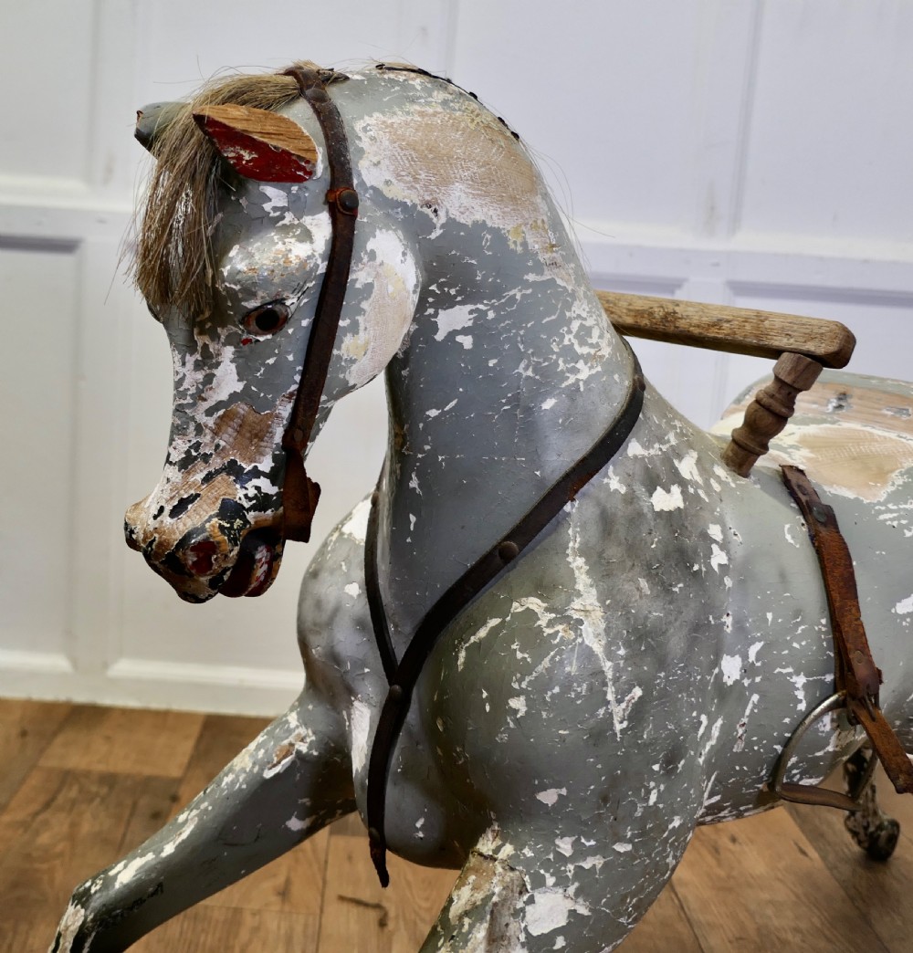 An early 19th-century hand-carved wooden horse featuring a distressed grey and white painted finish with leather harness and horsehair detail. View IV