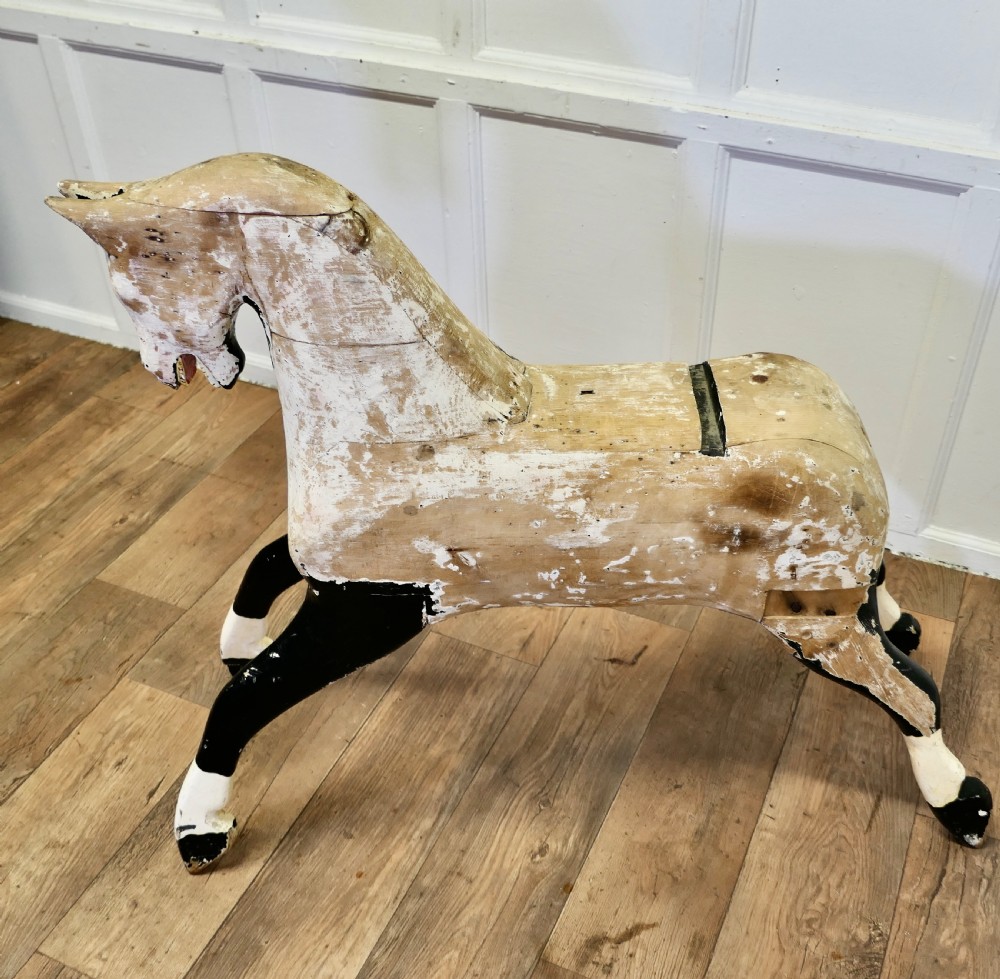 A large carved pine rocking horse figure with a heavily distressed off-white and black painted finish, detached from its original rocker base. View II