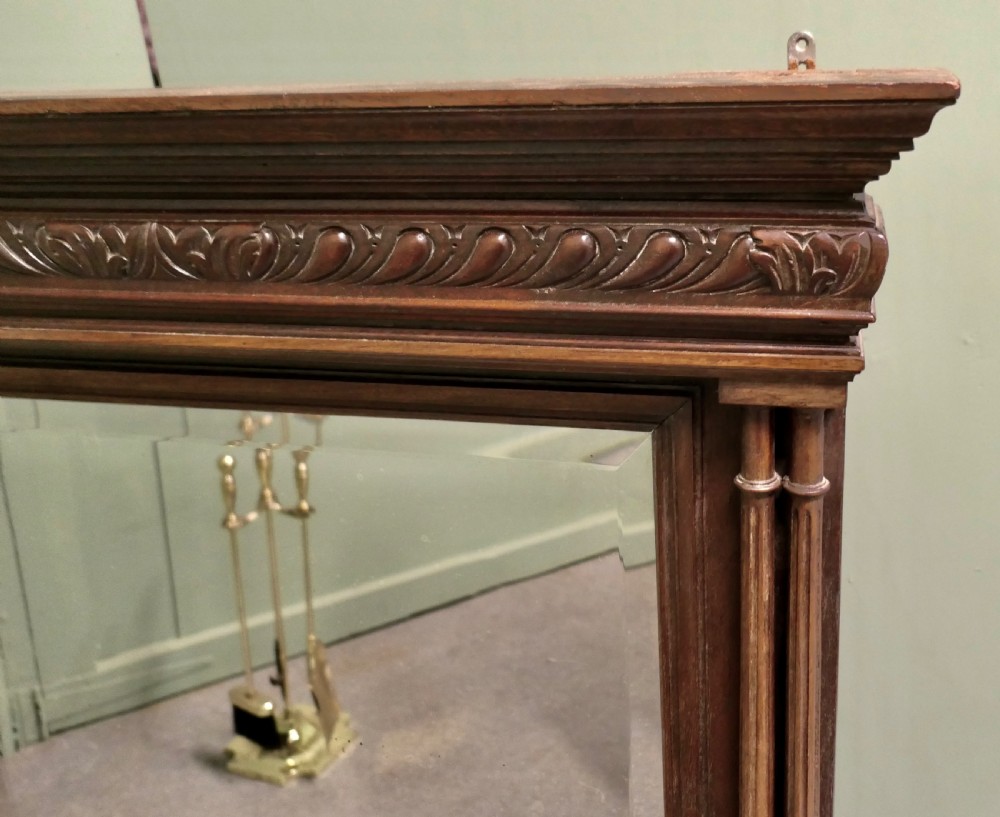 A dark oak rectangular wall mirror featuring an architectural carved cornice and twin slender columns flanking the glass plate. View III