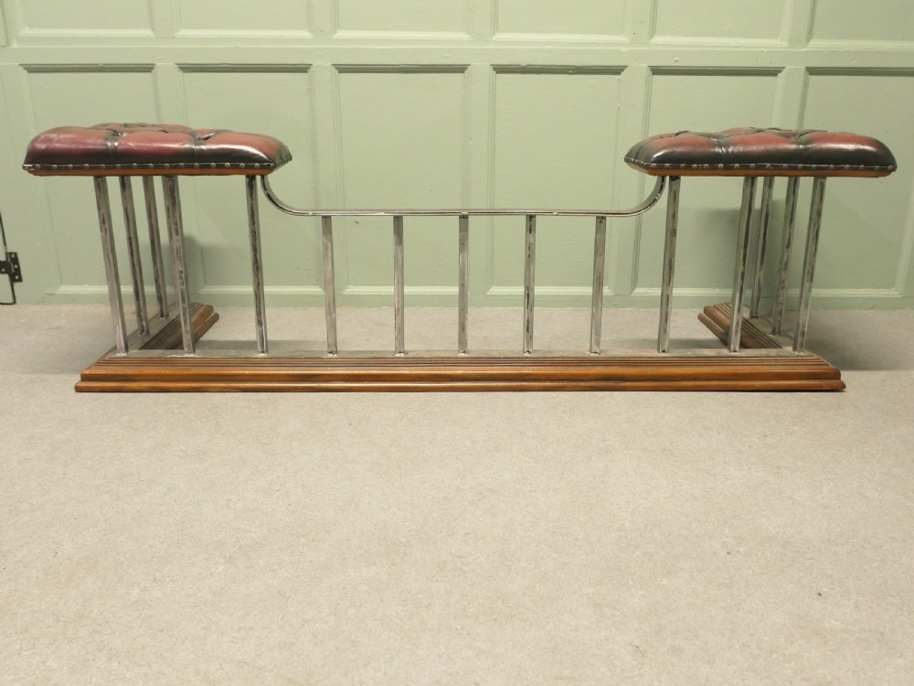 A Victorian brass club fender featuring vertical metal spindles, deep-buttoned red leather corner seats, and a moulded wooden base. View III
