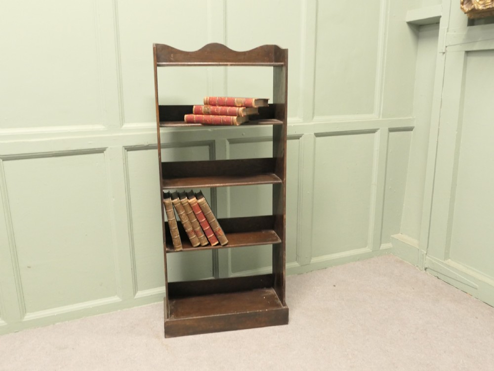 A tall dark wood Art Deco open bookcase featuring five shelves, a scalloped top rail, and a solid plinth base. View IV