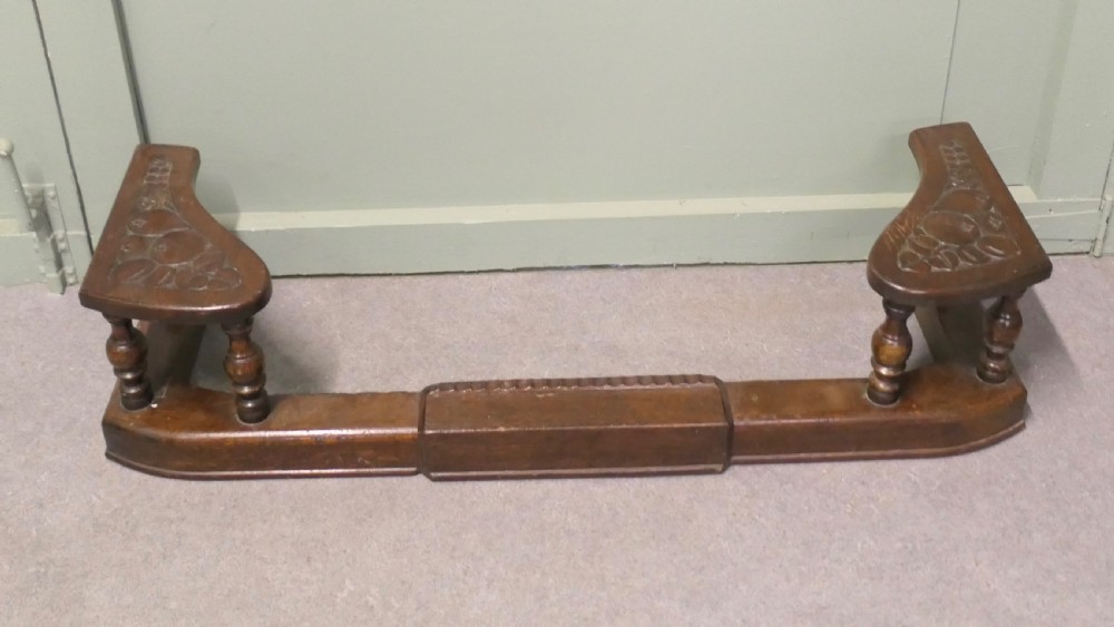 An Arts and Crafts carved oak adjustable club fender with turned baluster supports and decorative corner seats. View III