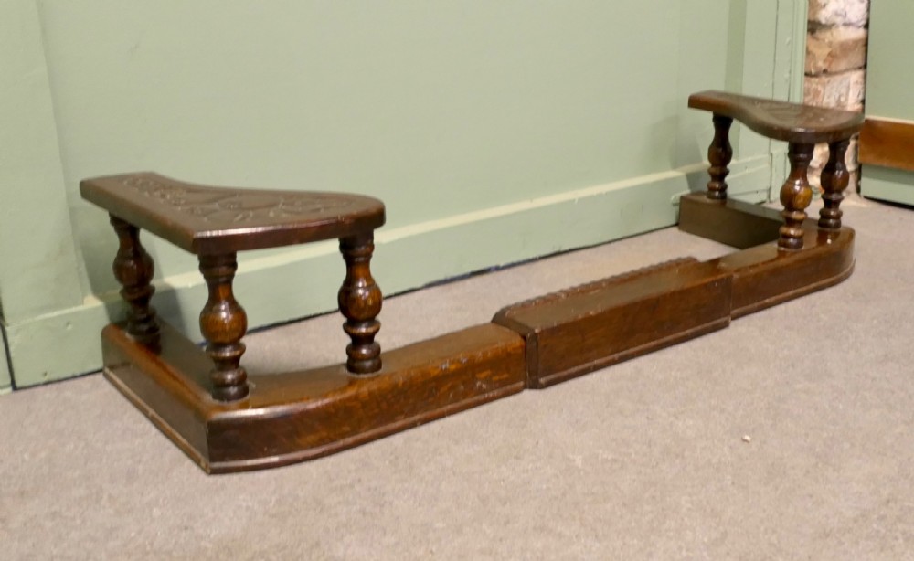 An Arts and Crafts carved oak adjustable club fender with turned baluster supports and decorative corner seats. View IV