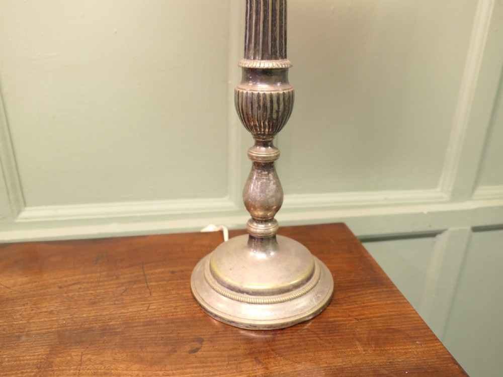 A pair of tall silver plated candlestick table lamps featuring reeded column stems and red and white striped shades. View II