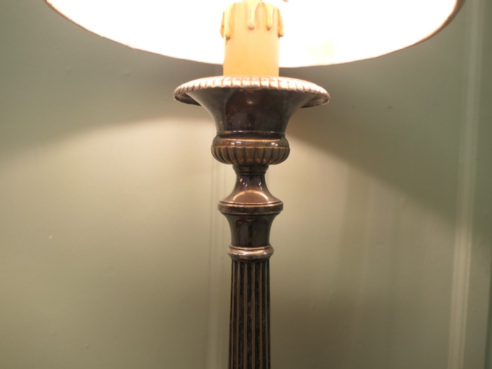 A pair of tall silver plated candlestick table lamps featuring reeded column stems and red and white striped shades. View VI