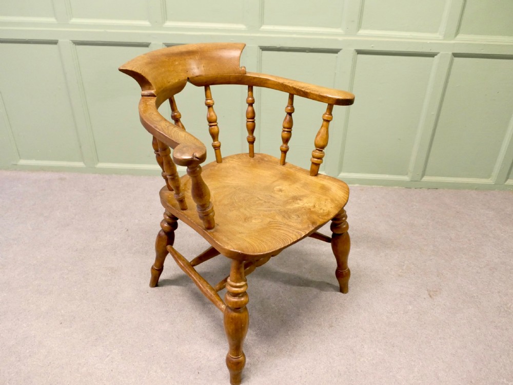 A 19th-century smokers bow armchair made from beech and elm with turned spindles and a contoured saddle seat. View III