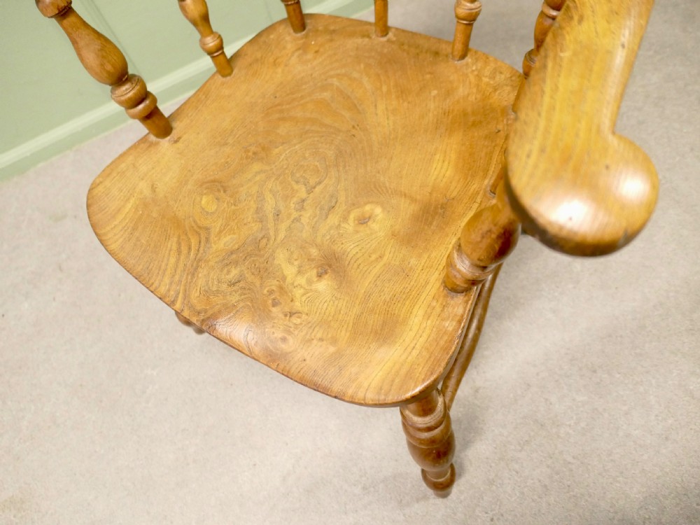 A 19th-century smokers bow armchair made from beech and elm with turned spindles and a contoured saddle seat. View IV