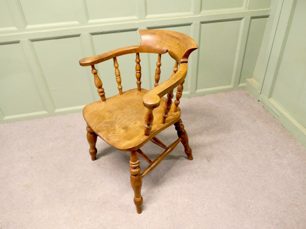 A 19th-century smokers bow armchair made from beech and elm with turned spindles and a contoured saddle seat. View V