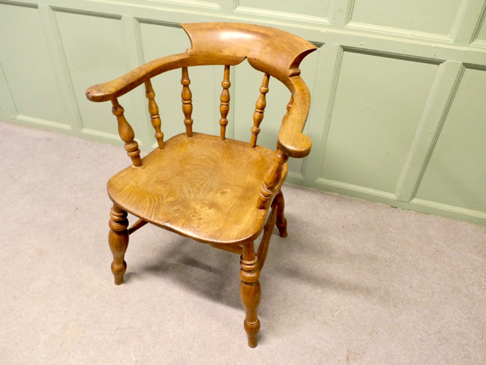 A 19th-century smokers bow armchair made from beech and elm with turned spindles and a contoured saddle seat. View VI