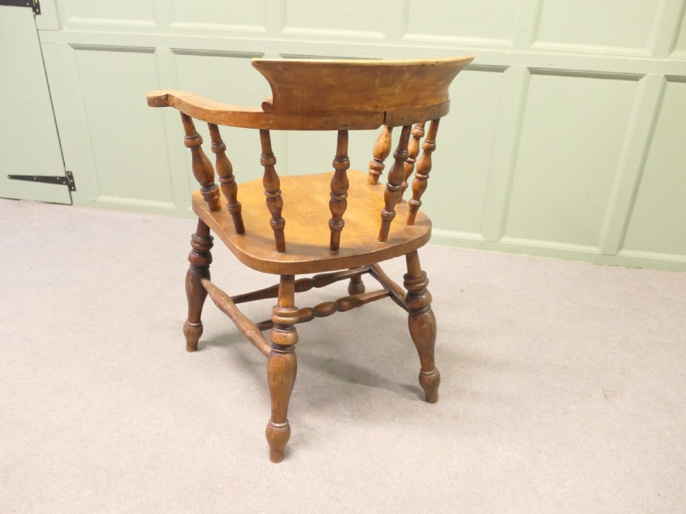 A 19th-century wooden smokers bow desk chair crafted from beech and elm with turned spindles and a shaped saddle seat. View II