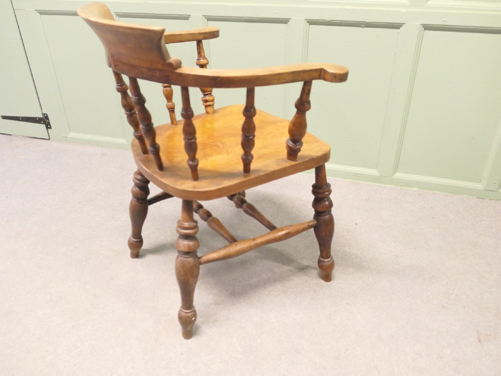 A 19th-century wooden smokers bow desk chair crafted from beech and elm with turned spindles and a shaped saddle seat. View VI