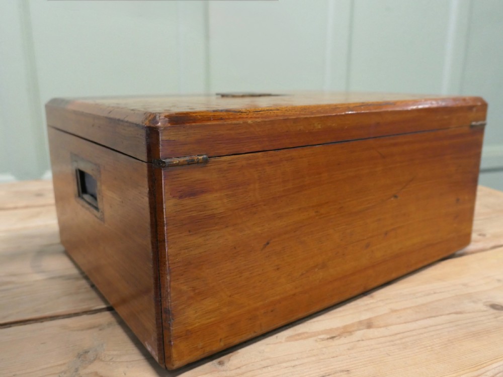 A rectangular warm brown Victorian oak presentation box featuring a hinged lid with a central brass monogrammed plaque and a keyhole on the front face. View II